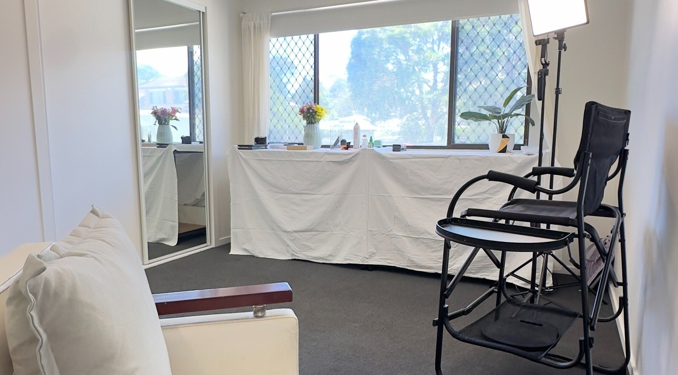 Calm and bright interior of Dreamy Looks By Kara, Ashmore, Queensland, AU. Features a makeup chair and mirror.