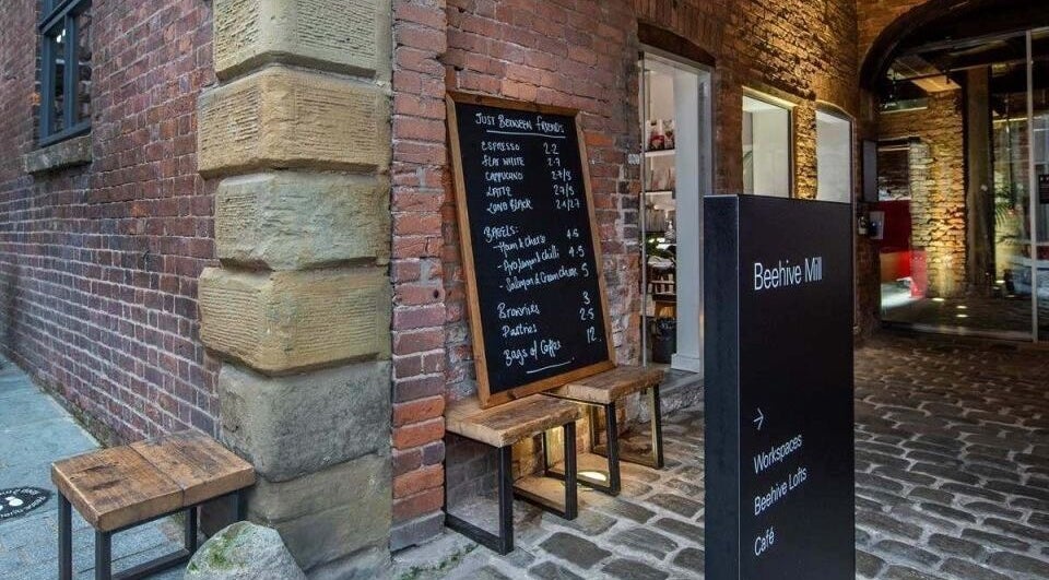 Entrance at Beehive Mill with menu board outside Manchester Lashes | Jean Studios in Ancoats, Manchester, England, GB.