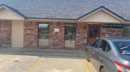 Entrance of Touch of Serenity Wellness Spa in Moore, Oklahoma with visible signage and parked car.
