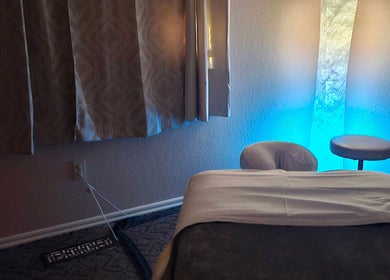 Calming massage room at Touch of Serenity Wellness Spa, Moore, Oklahoma, US, with blue ambient lighting.