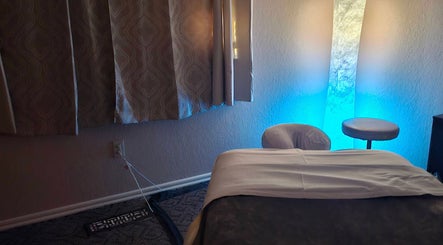 Calming massage room at Touch of Serenity Wellness Spa, Moore, Oklahoma, US, with blue ambient lighting.
