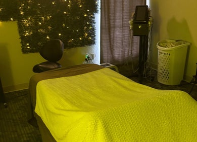 Cozy massage room at Touch of Serenity Wellness Spa, Moore, Oklahoma, US, with warm lighting and comfortable bed.