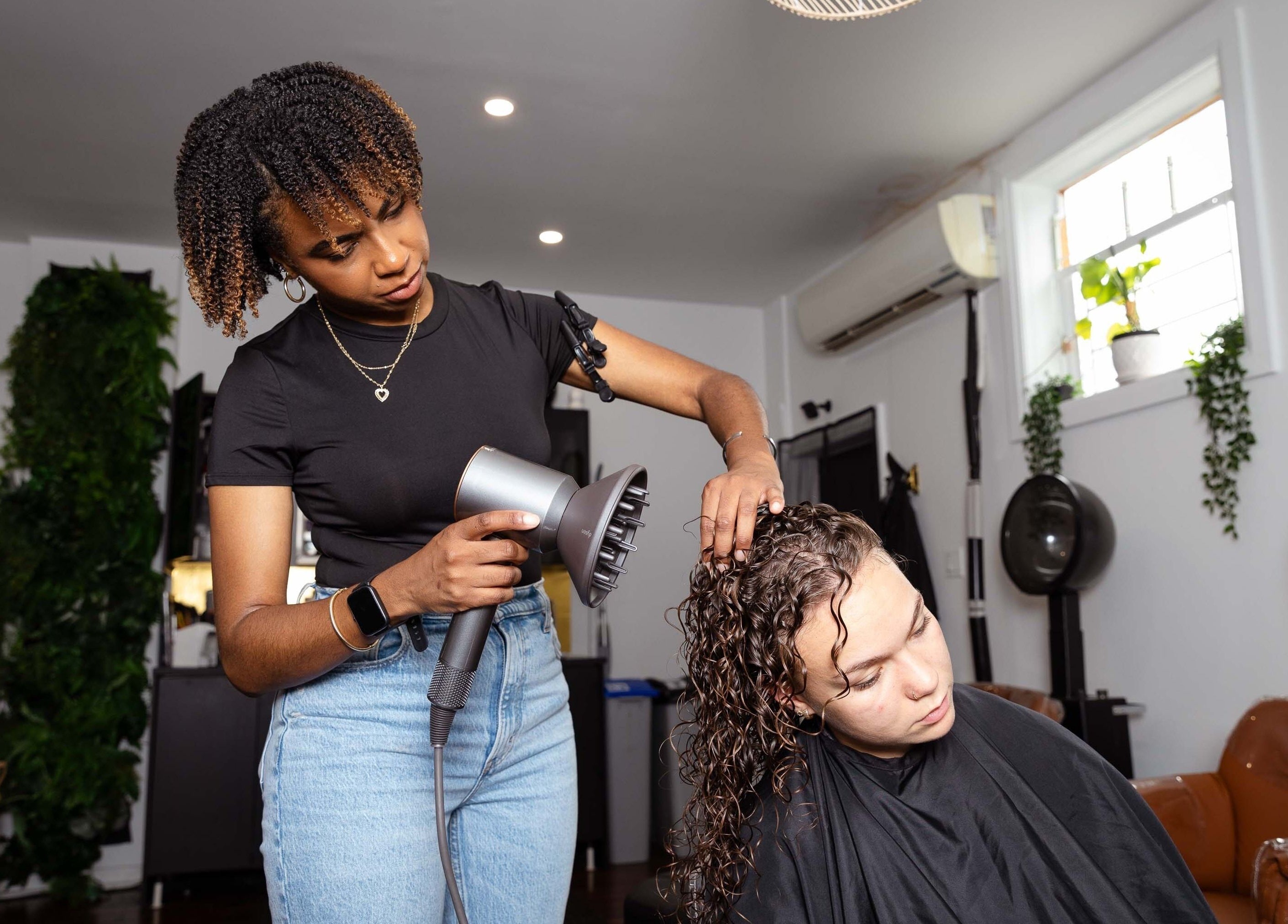 A stylist enhancing curls at The Curl Lounge, Toronto, Ontario, CA, with expert hair care techniques.