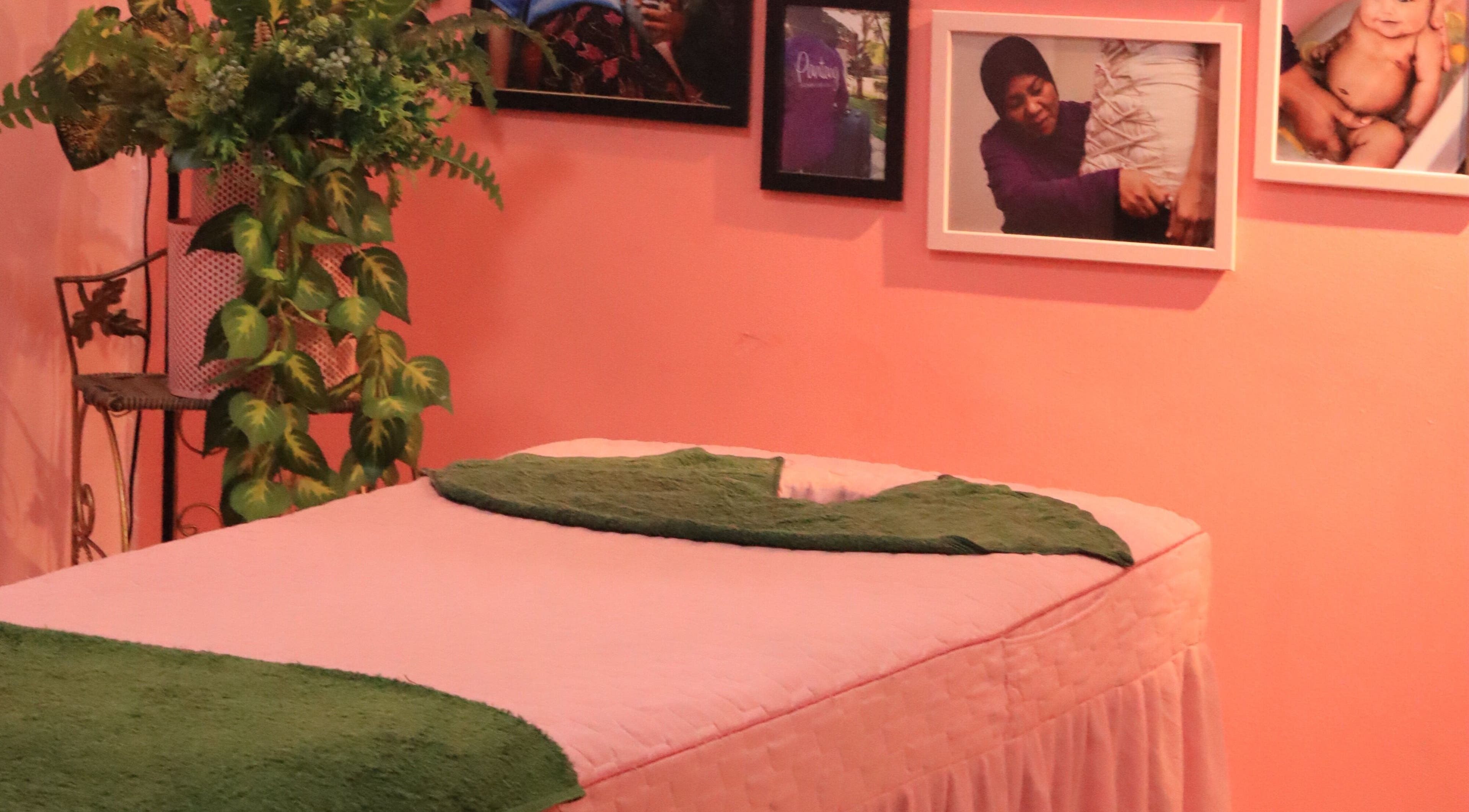 Cozy massage room at PMC Beauty & Herbs, Shah Alam, Selangor, MY with green decor and framed photos.