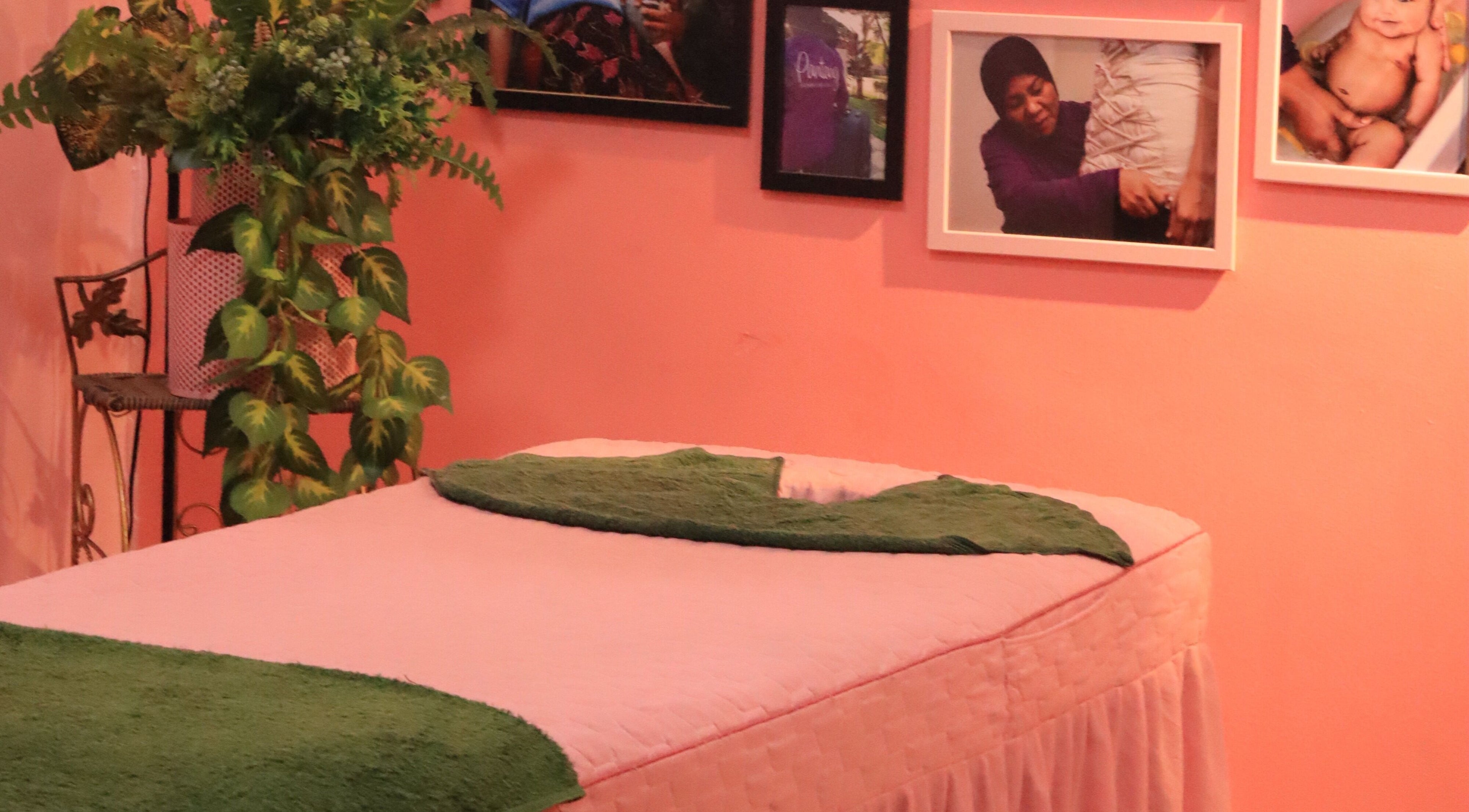 Cozy massage room at PMC Beauty & Herbs, Shah Alam, Selangor, MY with green decor and framed photos.