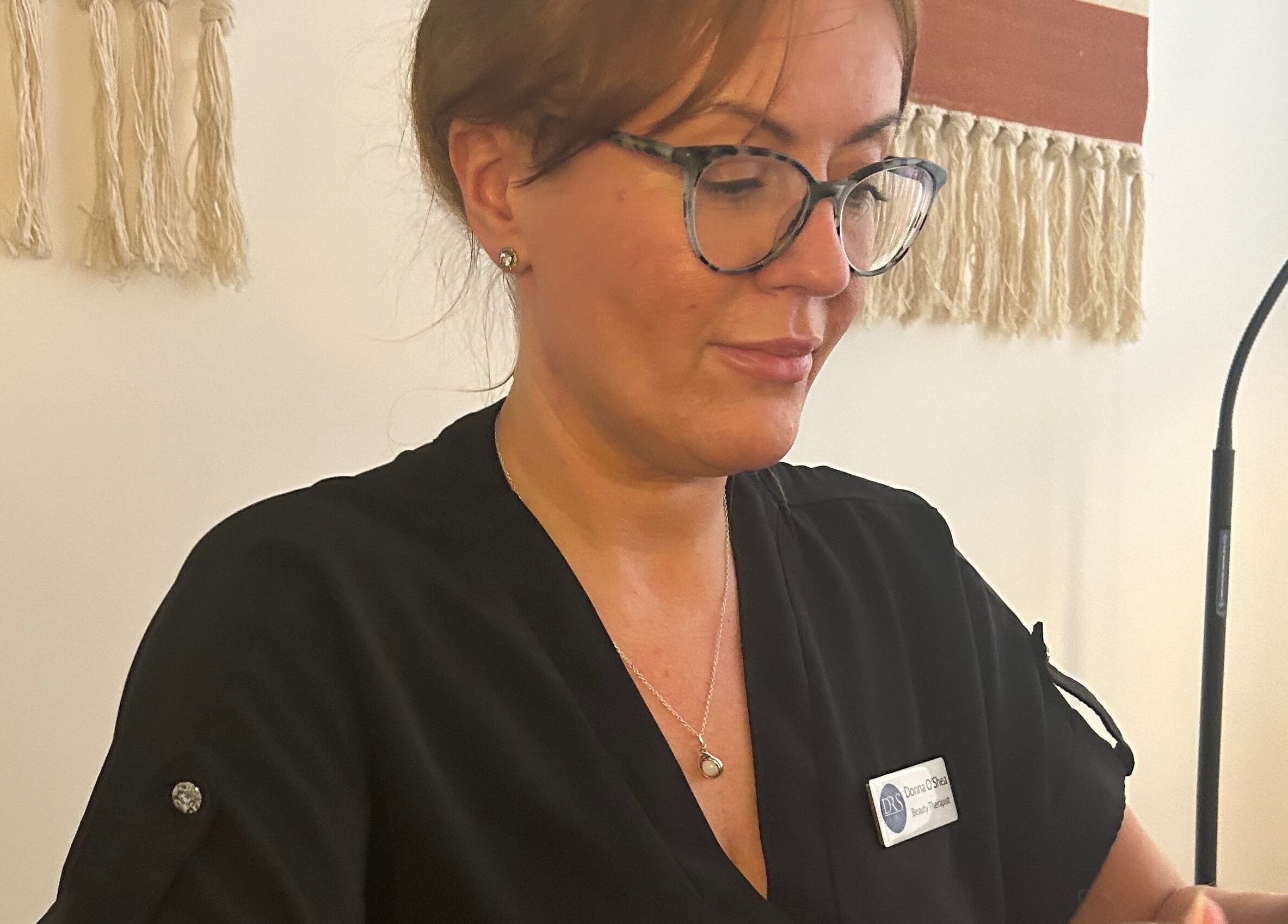 Beauty therapist at DR.S Clinic, Prestwich, England, GB, smiling while providing a service.