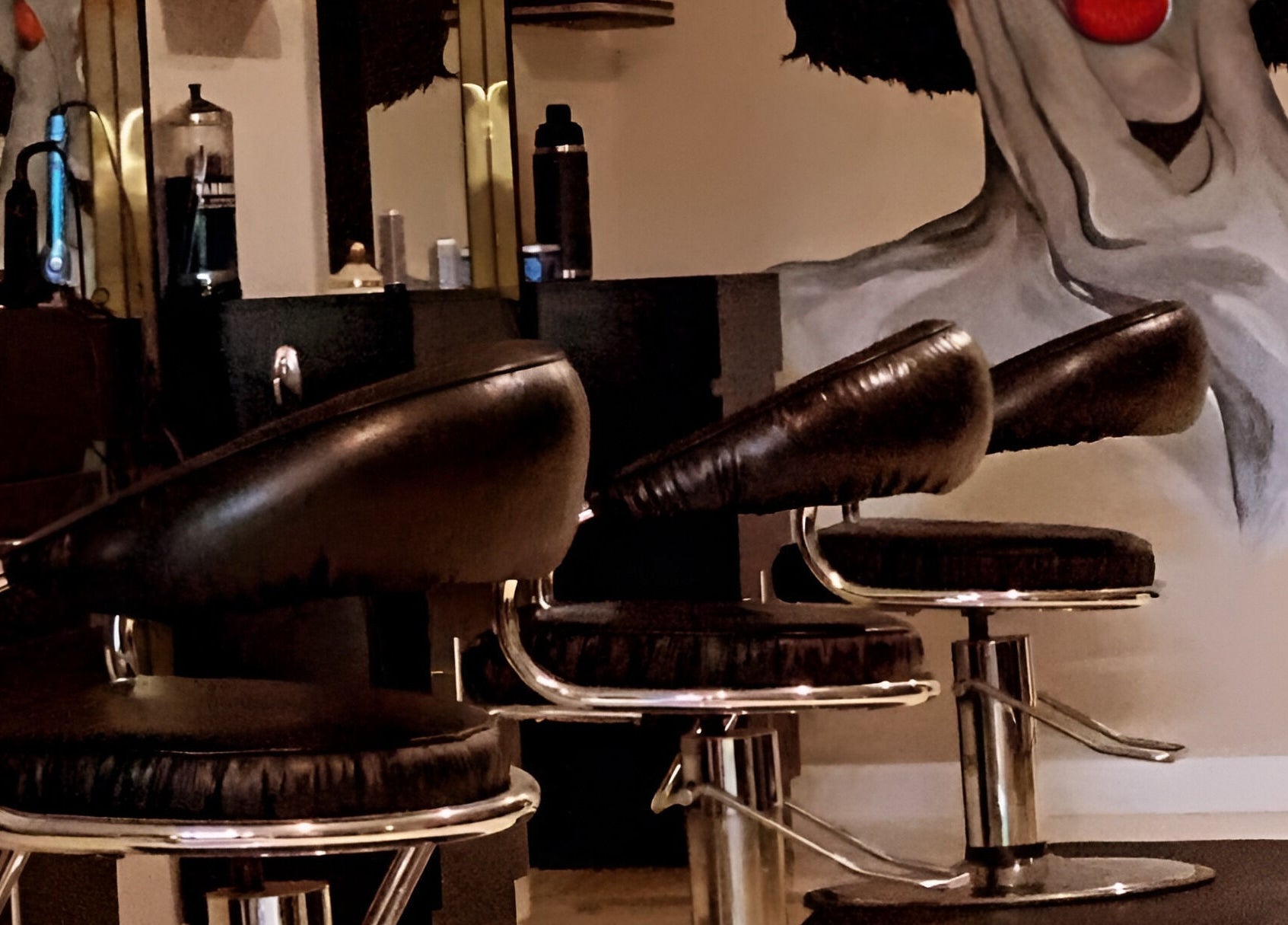 Elegant styling chairs at Salon Secora in Saugus, Massachusetts, US with artistic wall mural.