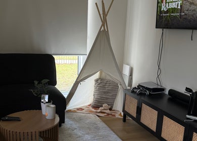 Relaxing corner at Luna-Luxe Beauty Bar, Geelong, Victoria, AU with a teepee, sofa, and sleek TV setup.