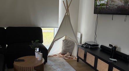 Relaxing corner at Luna-Luxe Beauty Bar, Geelong, Victoria, AU with a teepee, sofa, and sleek TV setup.