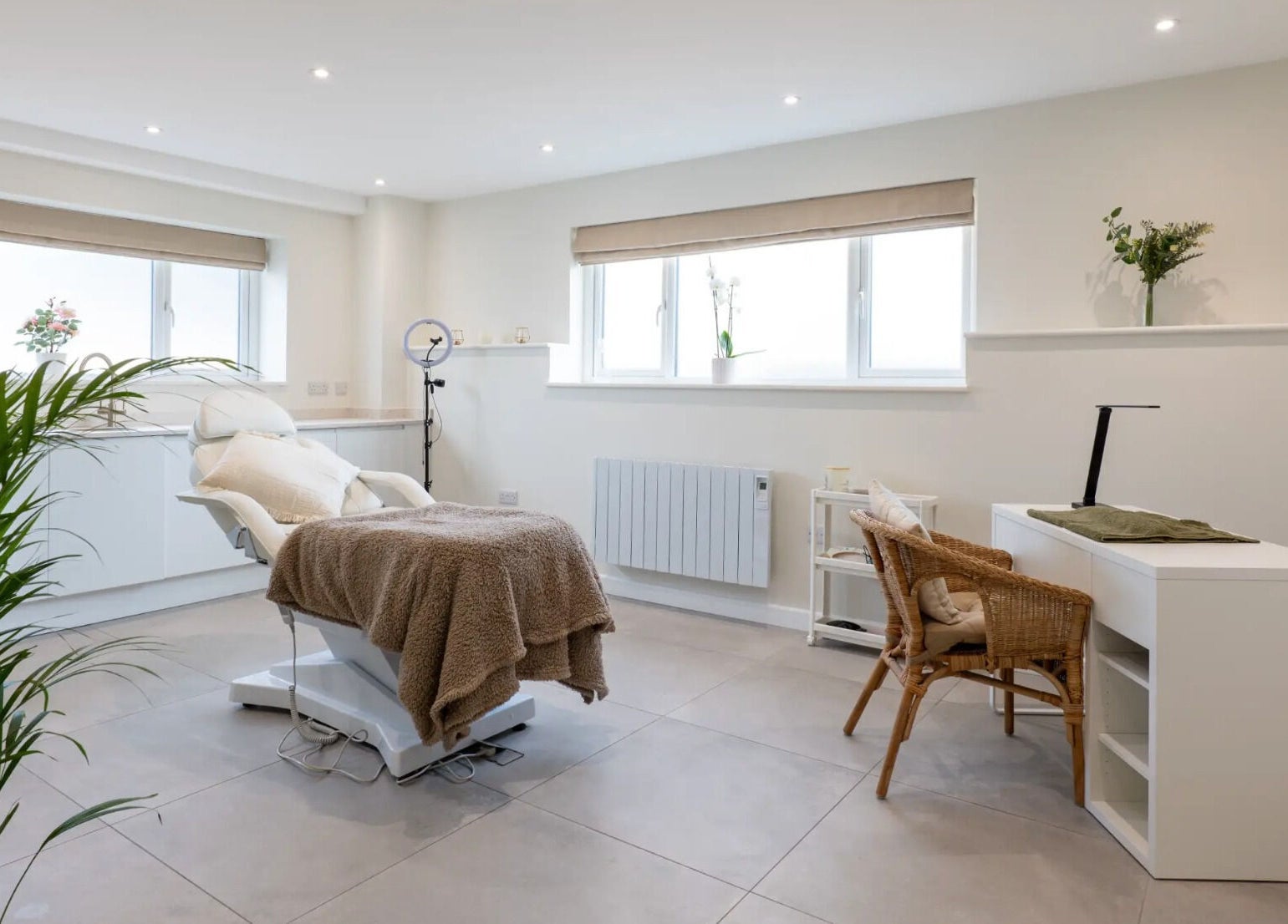Bright treatment room at Simple Beauty in Cullompton, England, with a comfy chair and modern decor.