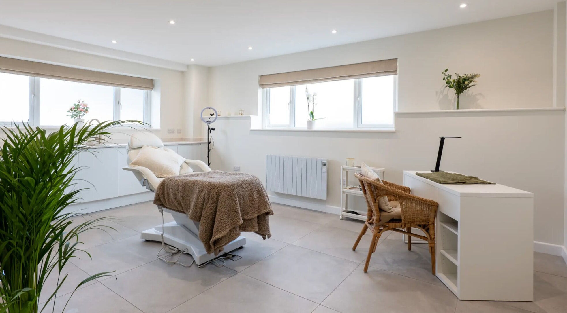 Bright treatment room at Simple Beauty in Cullompton, England, with a comfy chair and modern decor.