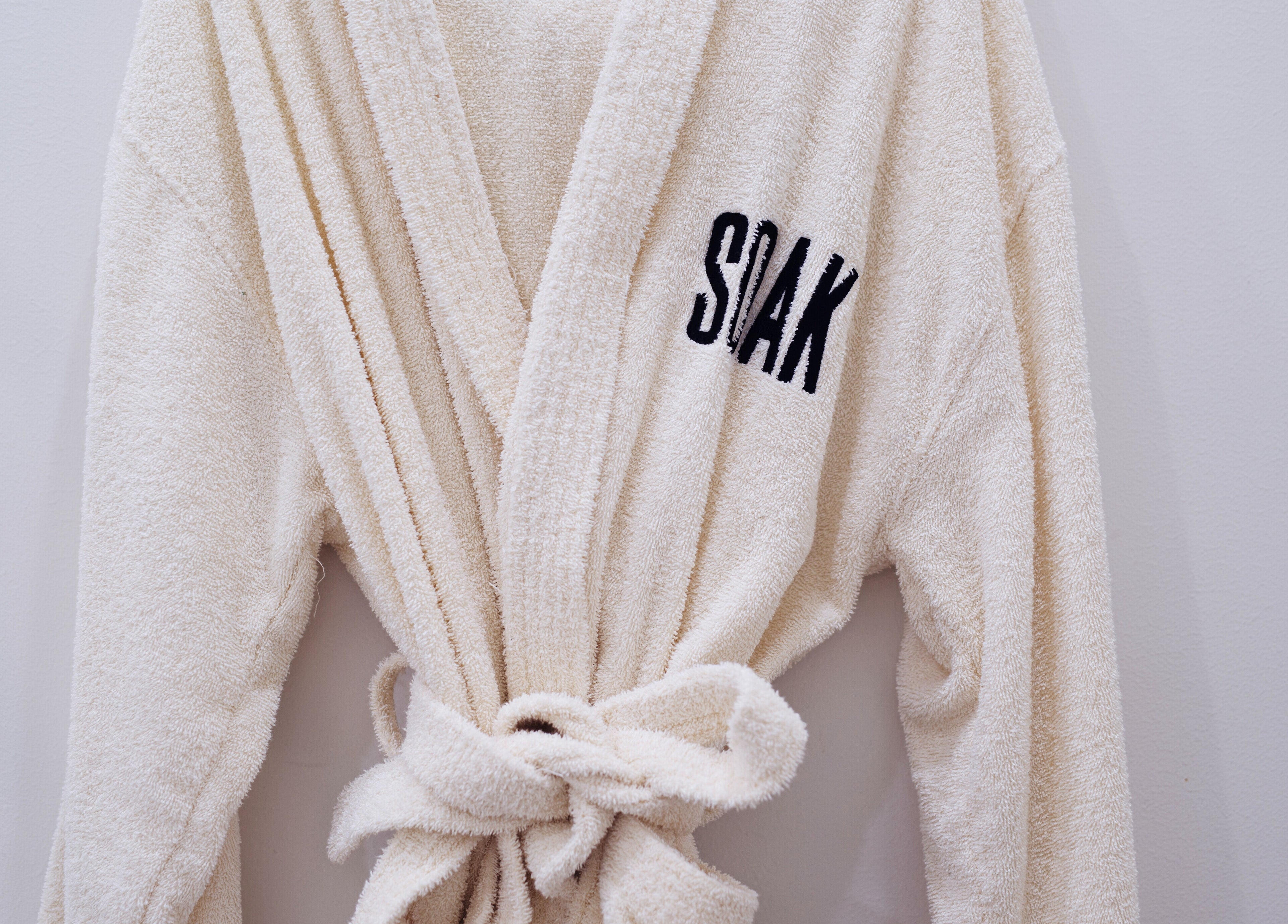 Elegant spa robe with Soak Salon logo at Dubai, AE, symbolizing relaxation and luxury.