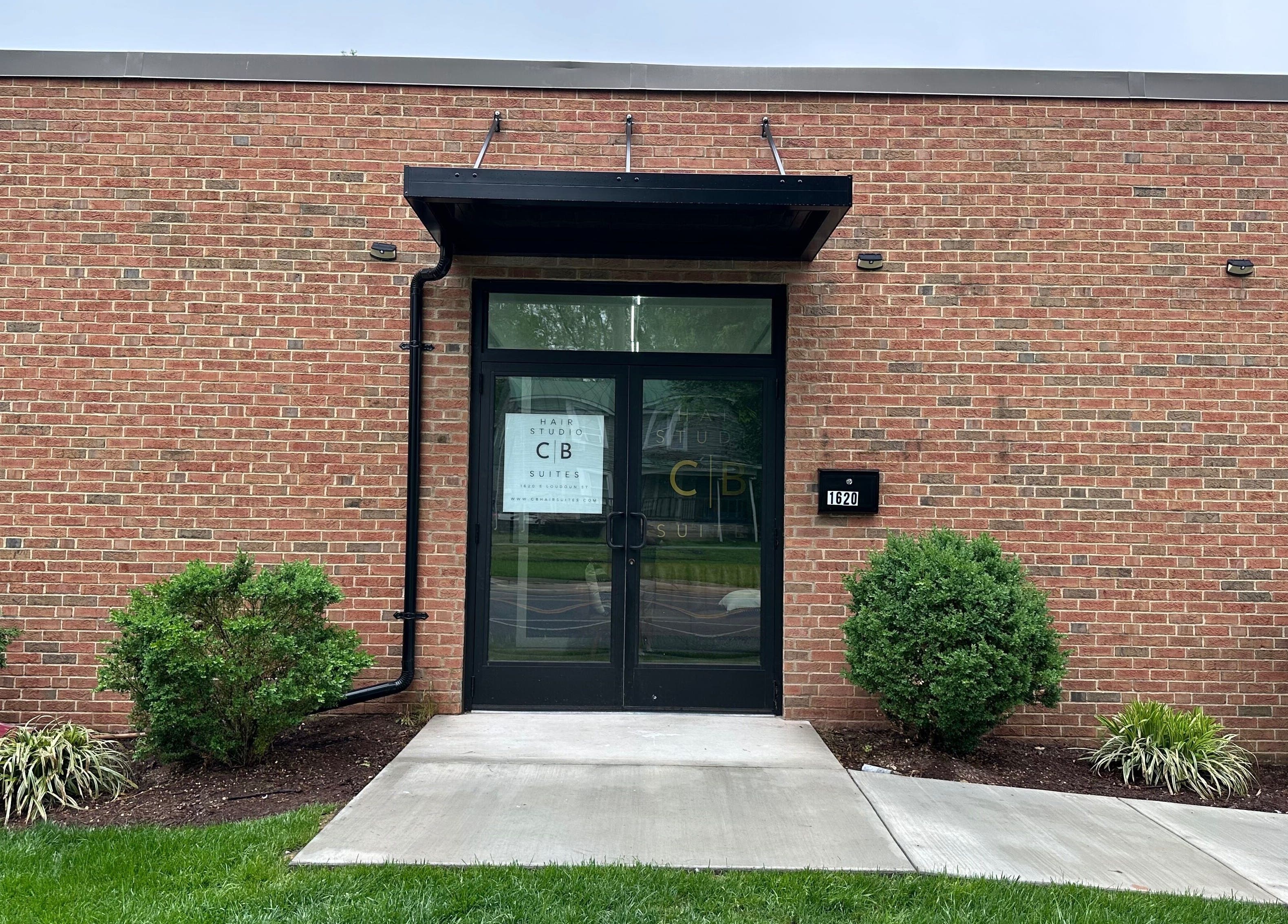 Entrance of Serenity Massage, a brick building in Winchester, Virginia, US with a clear glass door.