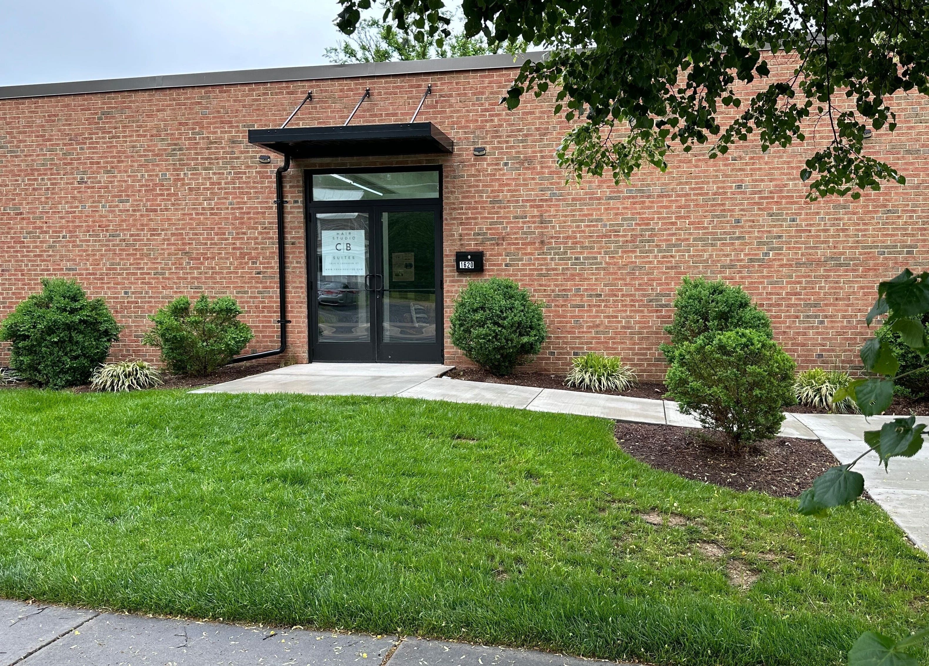 Entrance to Serenity Massage, Winchester, Virginia, US, featuring brick facade and manicured greenery.
