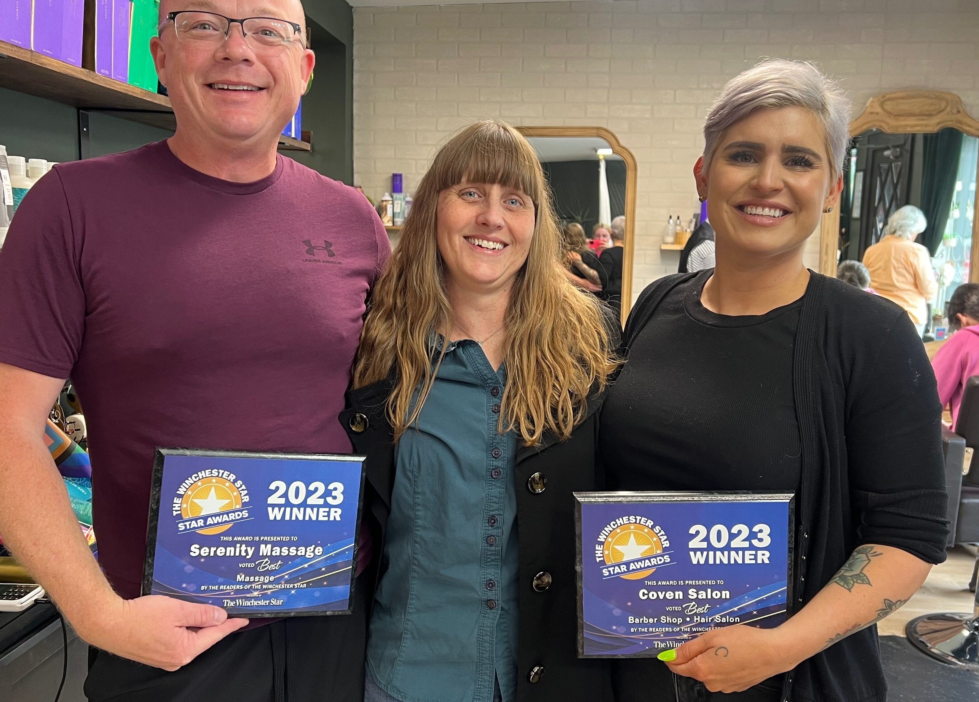 Proud winners at Serenity Massage, Winchester, Virginia, US, celebrating with awards in a lively salon setting.