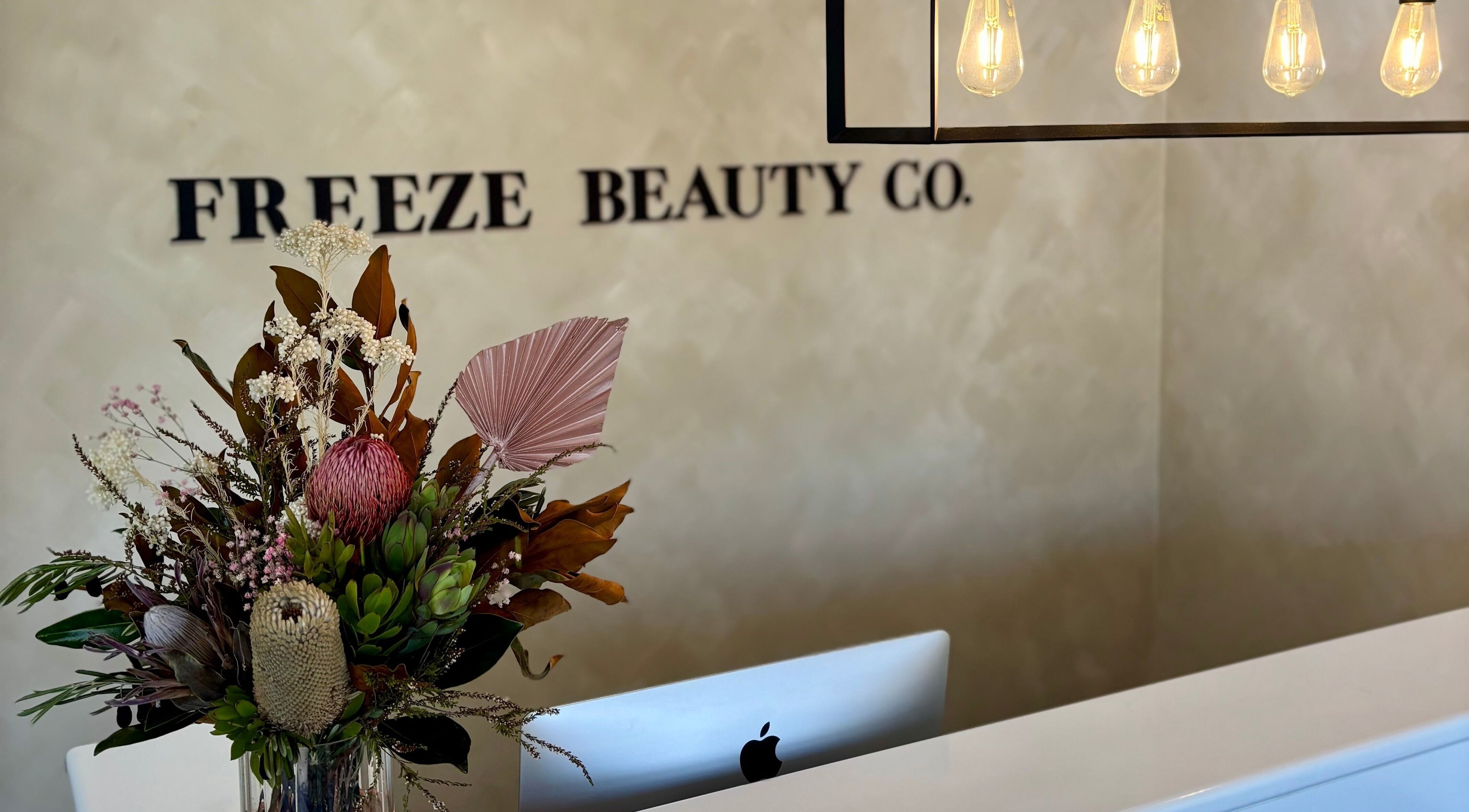 Reception area at Freeze Beauty Co. Bulimba featuring a floral arrangement, Bulimba, Queensland, AU.