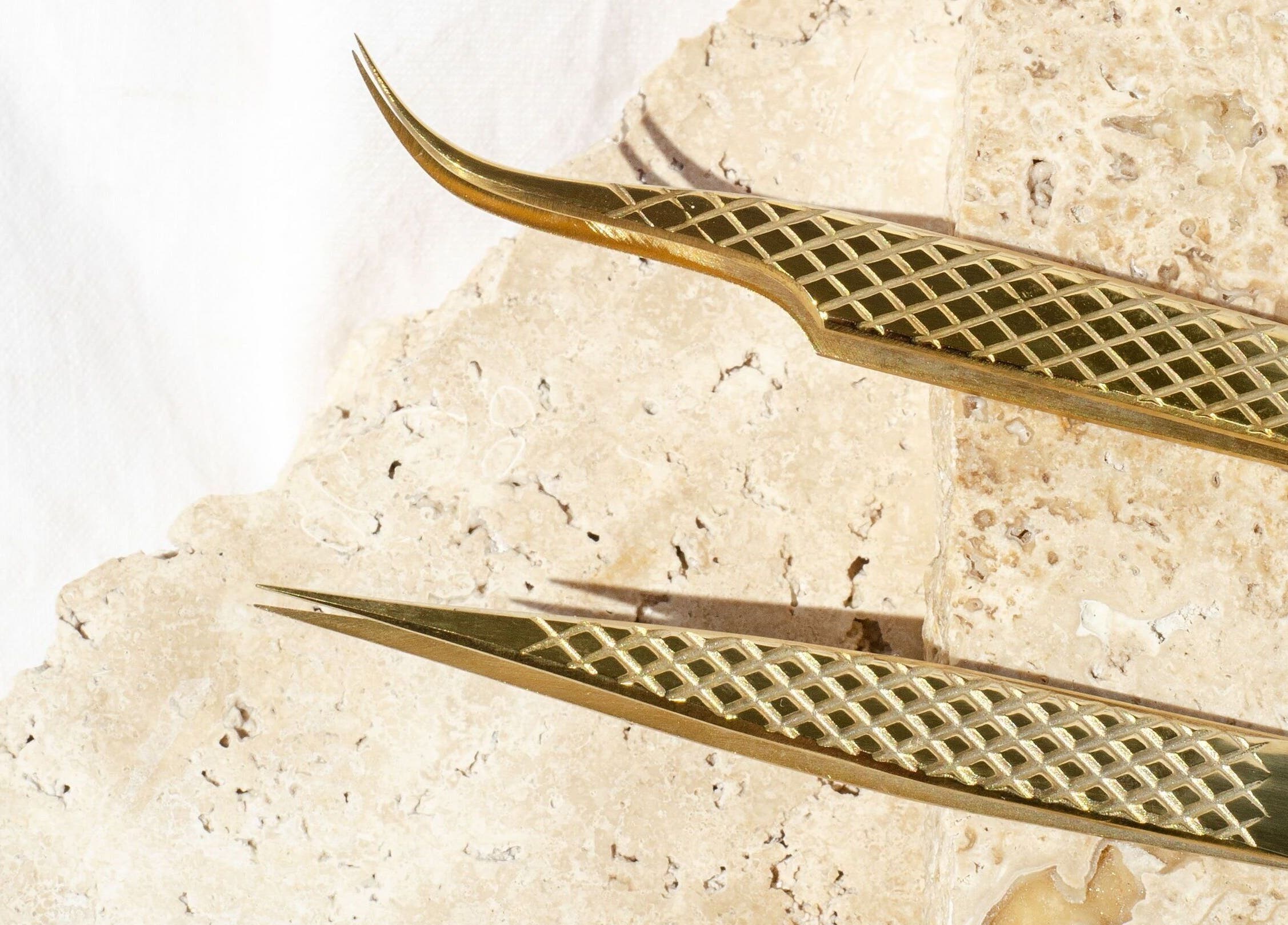 Gold eyelash tweezers on stone at Coastal Lash Co., Maroochydore, Queensland, AU.
