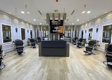 Spacious interior of BRILLIANT STYLES GENTS SALON in Al Barsha, Dubai, showcasing stylish barbershop seating.