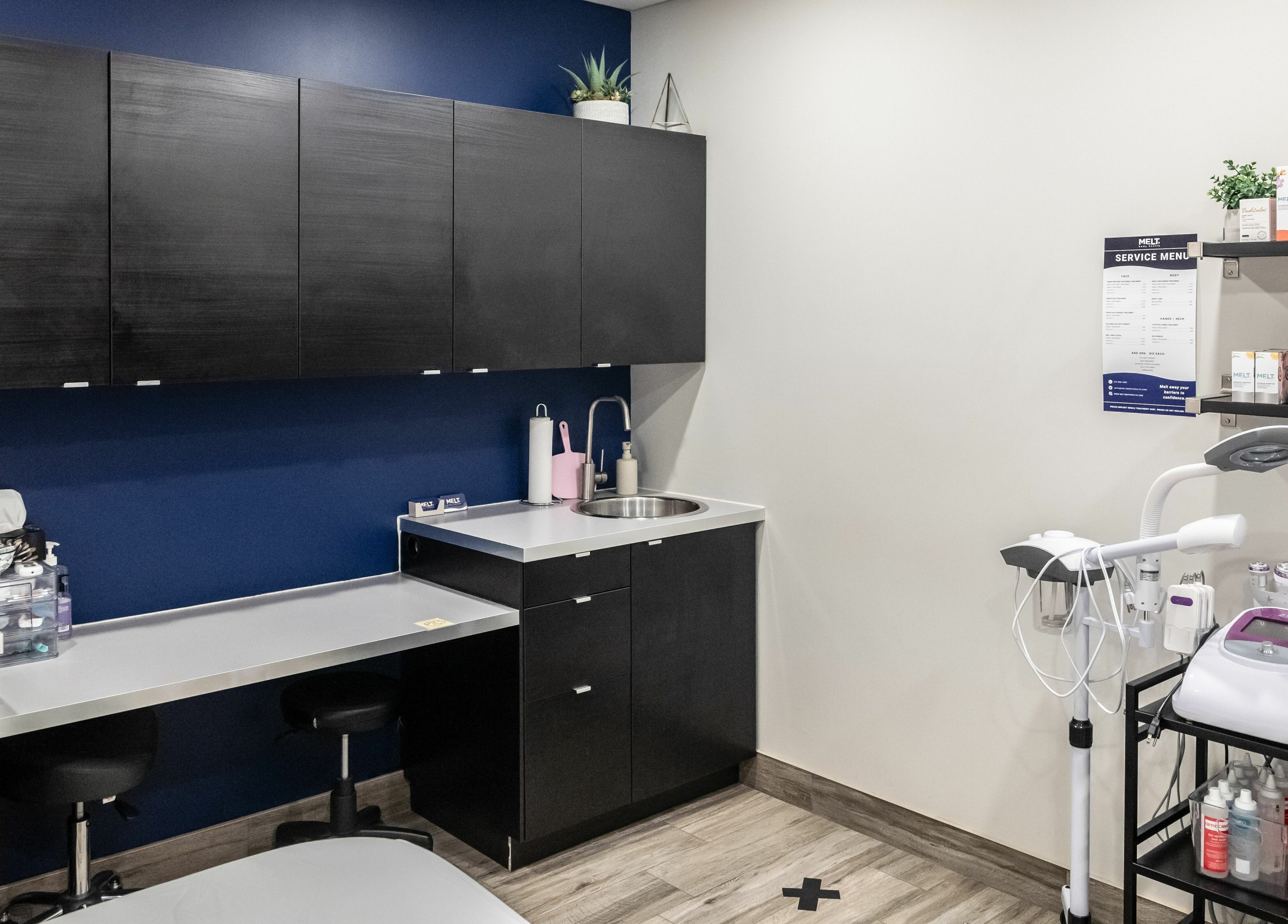 Modern treatment room at Melt Body Health, Windsor, Ontario, CA, showcasing sleek cabinetry and wellness equipment.