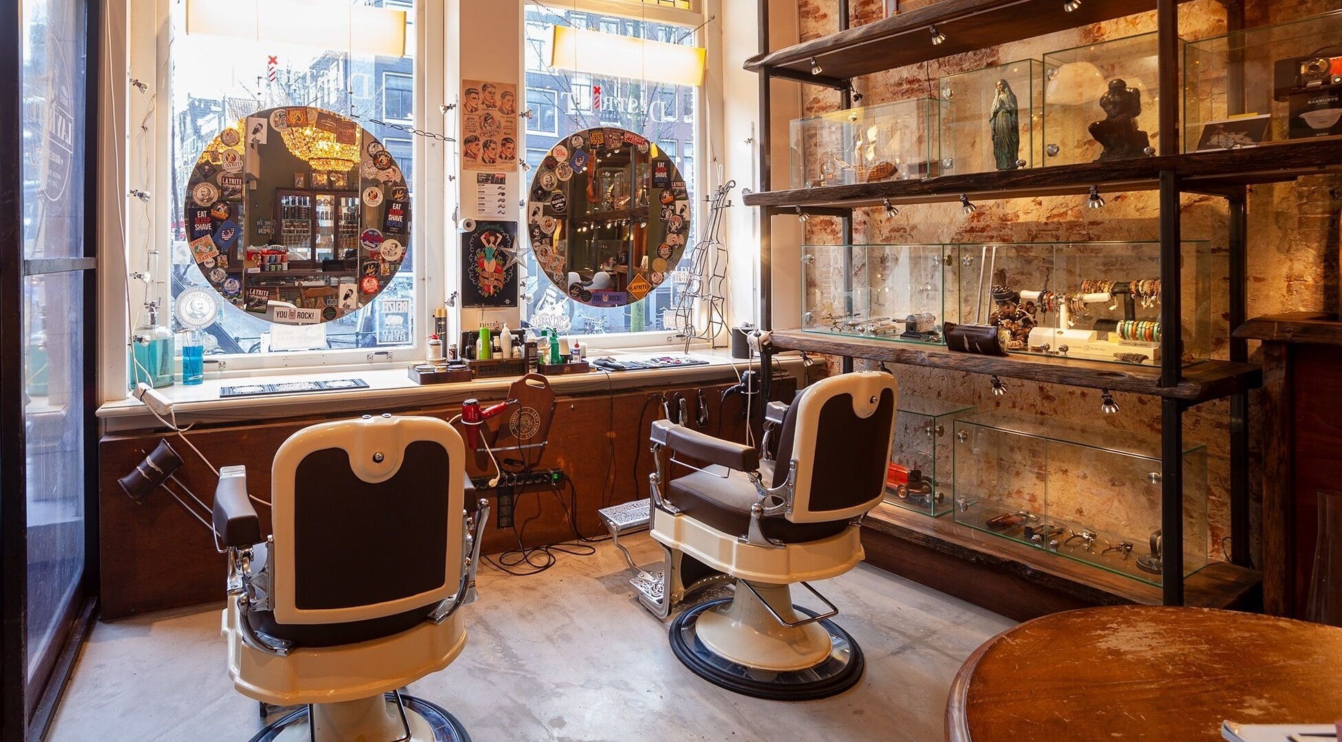 Interieur van DISTRICT BARBER in Amsterdam, Noord-Holland, NL, met vintage barbierstoelen en decoratieve rekken.