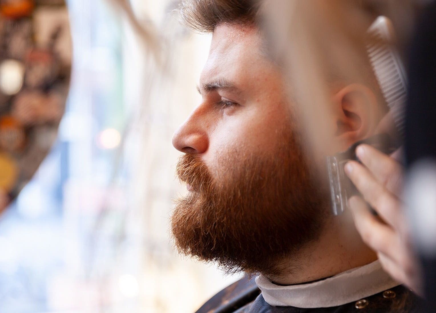 Man krijgt stijlvolle baardtrimming bij DISTRICT BARBER, Amsterdam, Noord-Holland, NL.