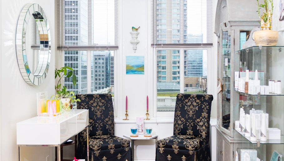 Chic lounge at Lumière Spa Downtown Vancouver, British Columbia, CA, with floral chairs and skyline view.