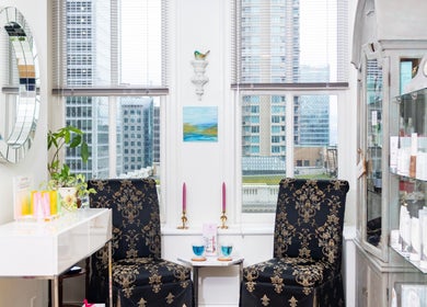 Chic lounge at Lumière Spa Downtown Vancouver, British Columbia, CA, with floral chairs and skyline view.