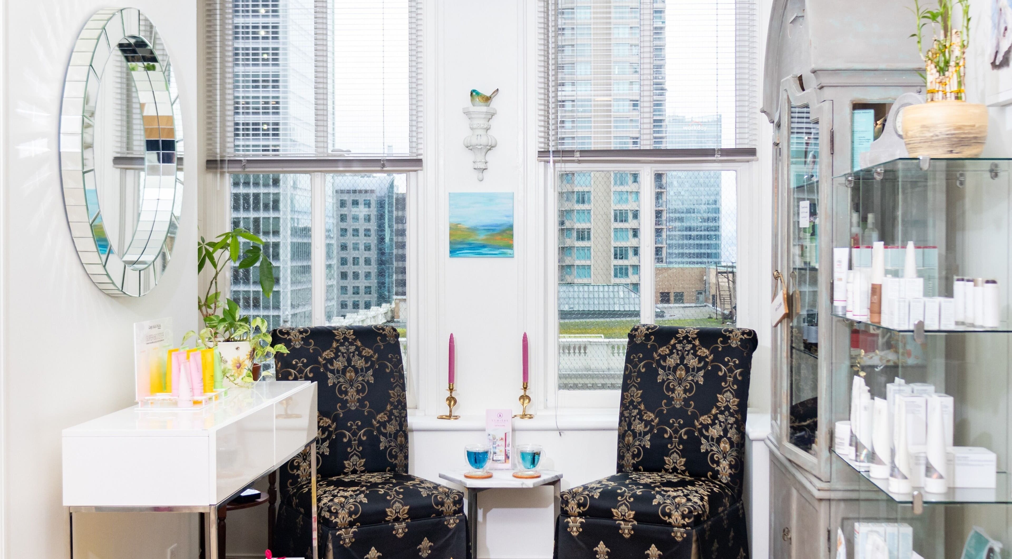 Chic lounge at Lumière Spa Downtown Vancouver, British Columbia, CA, with floral chairs and skyline view.