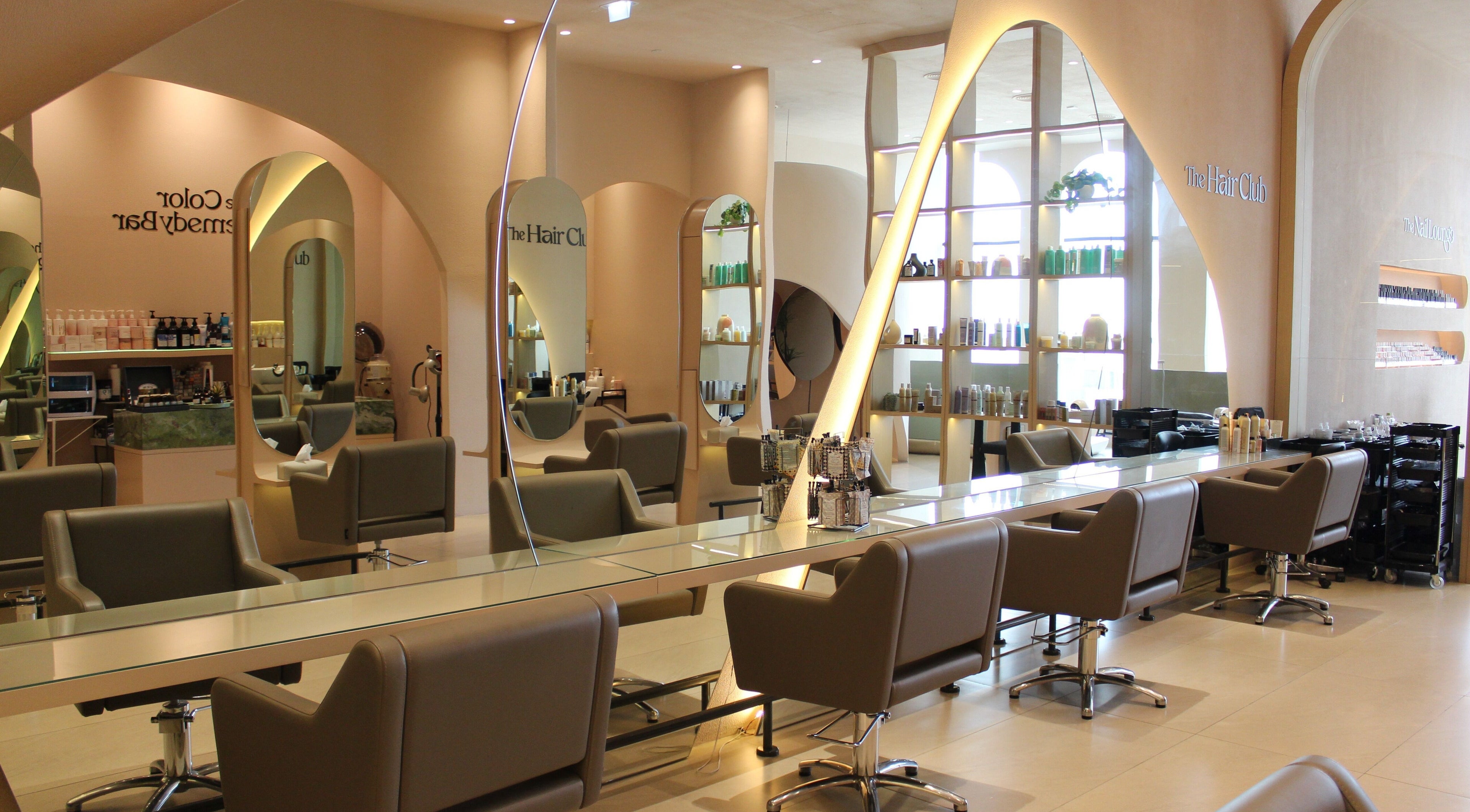 Elegant interior of The Beauty Society in Dubai, AE, featuring sleek salon chairs and modern decor.