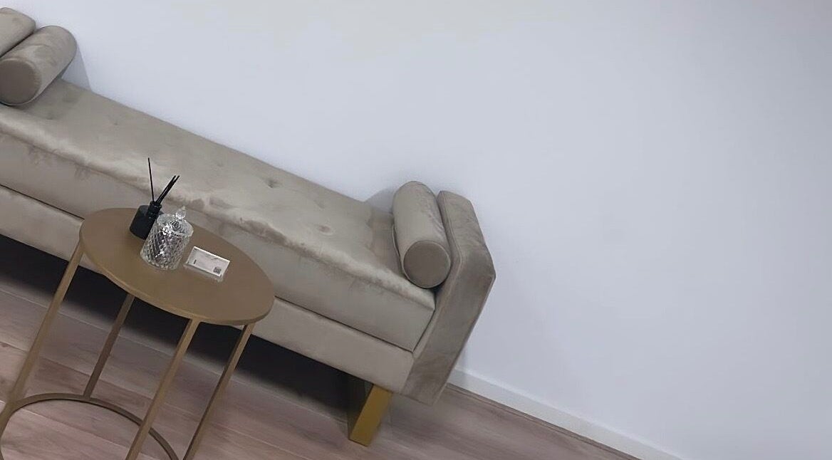 Stijlvolle wachtruimte bij Prettylashedthing, Haarlem, Noord-holland, NL met elegante bank en bijzettafel.