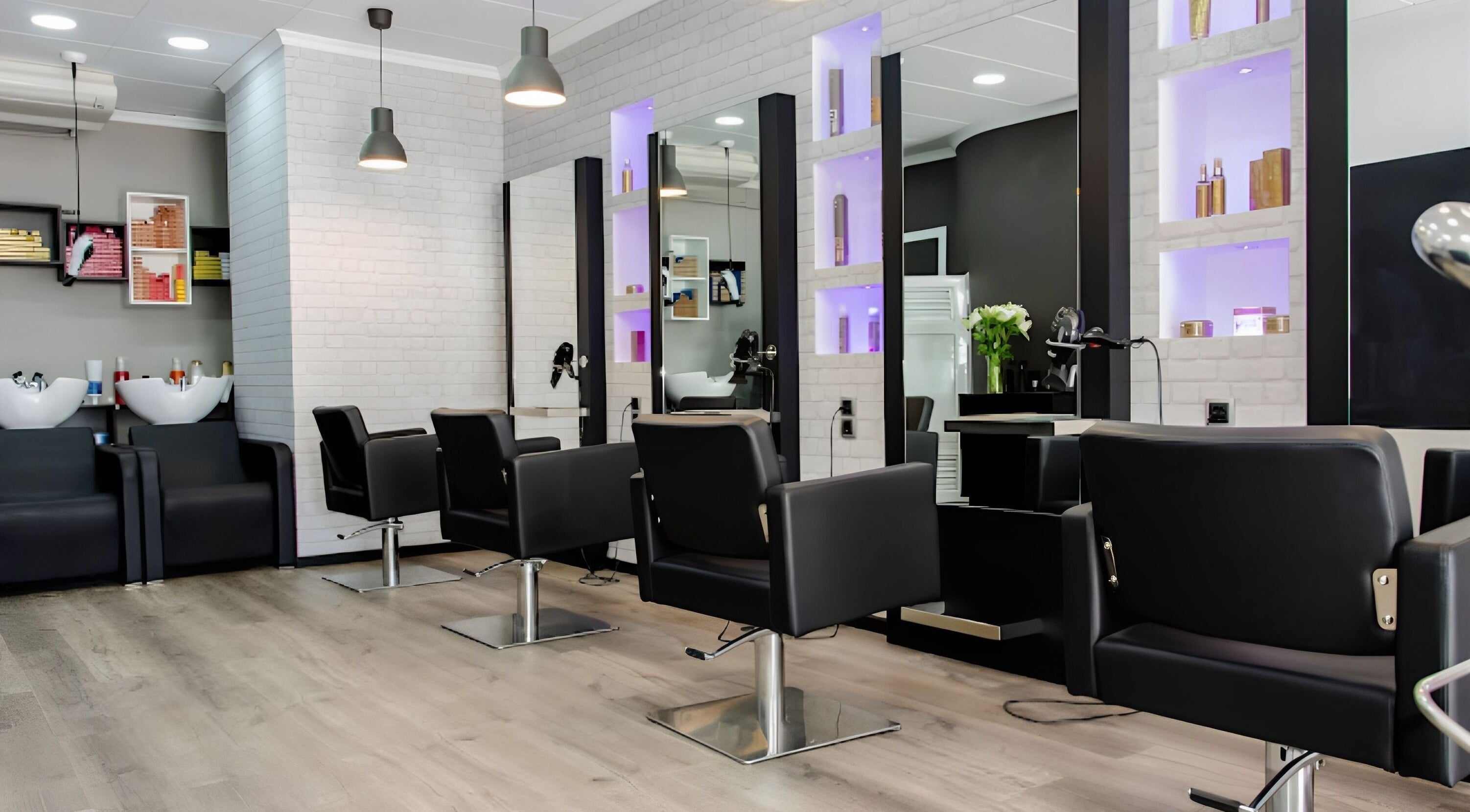 Interior moderno del salón Woman Style en Garrucha, Andalucía, ES con sillas elegantes y tocadores iluminados.