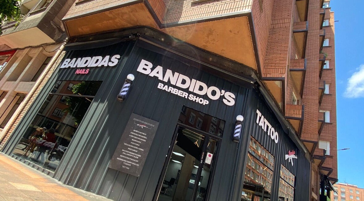 Fachada de Bandido’s Barber Shop en Gijón, ES, mostrando un diseño moderno y servicios variados.
