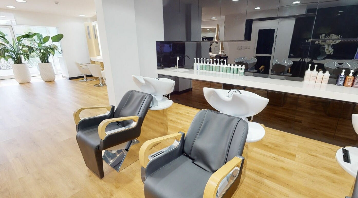 Modern salon interior at Dessange, Dubai, Dubai, AE, featuring sleek styling chairs and vibrant decor.