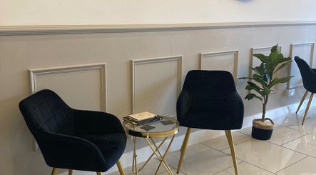 Elegant seating area with black chairs and plant at Lucy Angel, Lowestoft, GB.