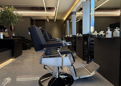 Modern barber shop interior in Barber, Amman, Amman Governorate, JO with black chairs and sleek decor.