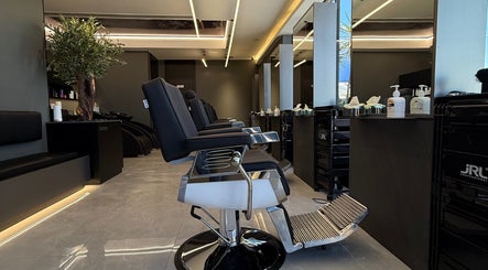 Modern barber shop interior in Barber, Amman, Amman Governorate, JO with black chairs and sleek decor.