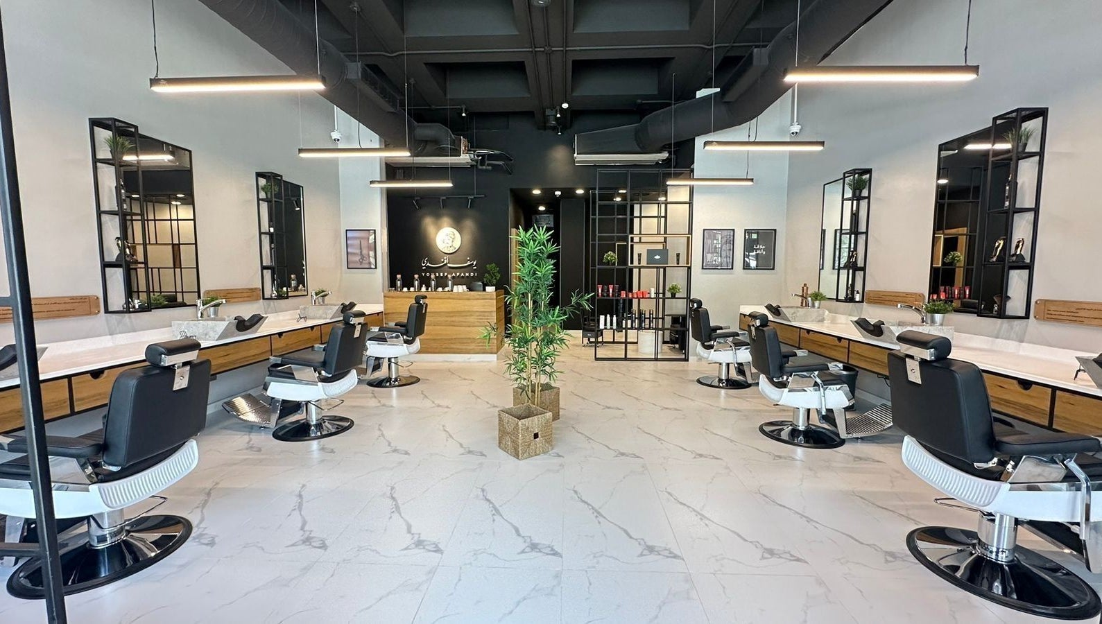Interior view of Yousef Afandi Express- University of Jordan in Amman, showcasing modern barber chairs and decor.