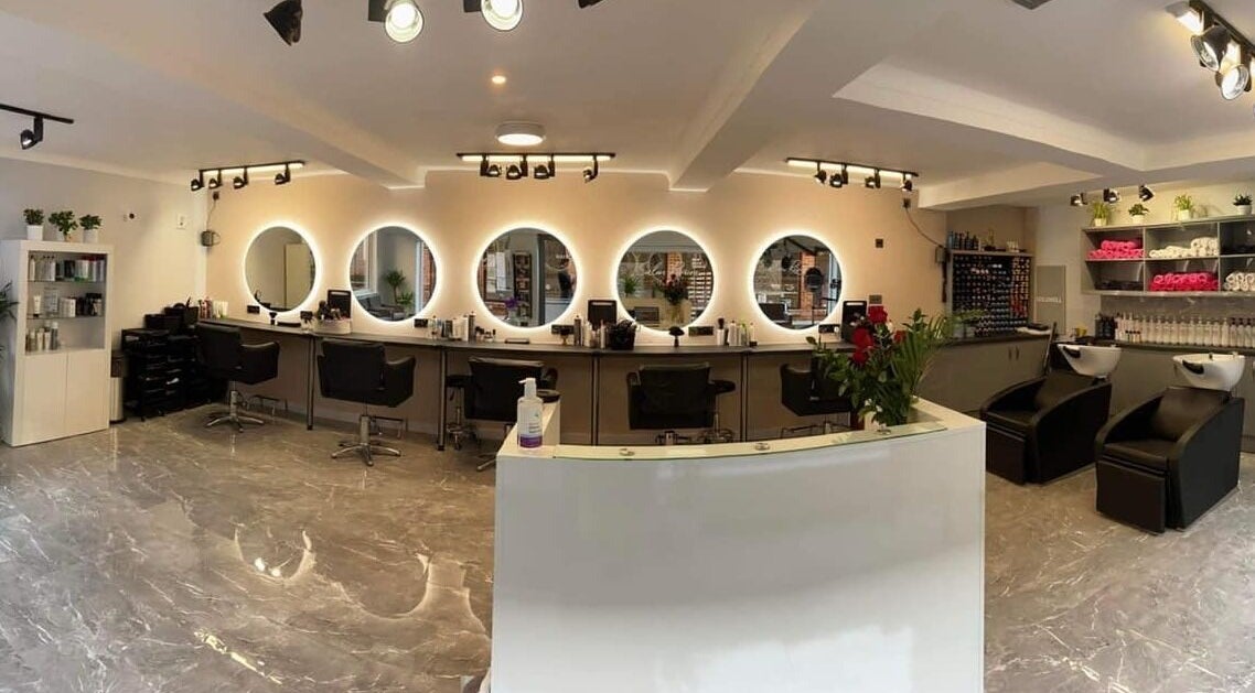Elegant salon interior at Salon Riviera, Blandford Forum, England, GB featuring stylish mirrors and seating.