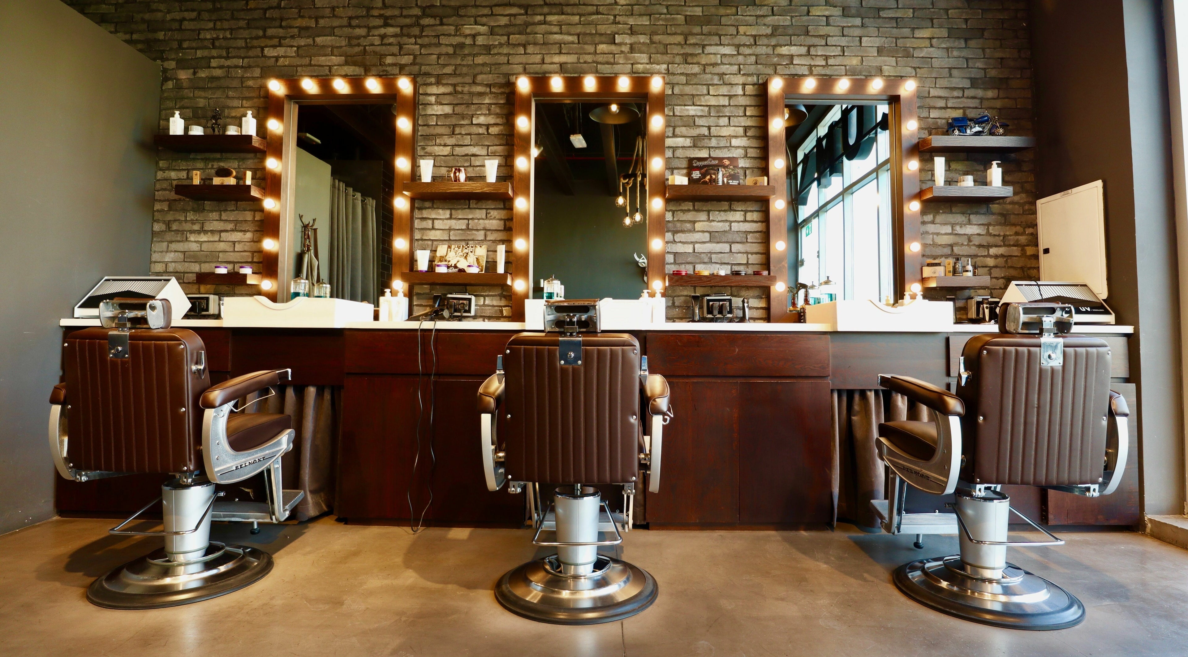 Interior of Musk Barbershop JVT in Dubai, Dubai, AE with vintage barber chairs and illuminated mirrors.