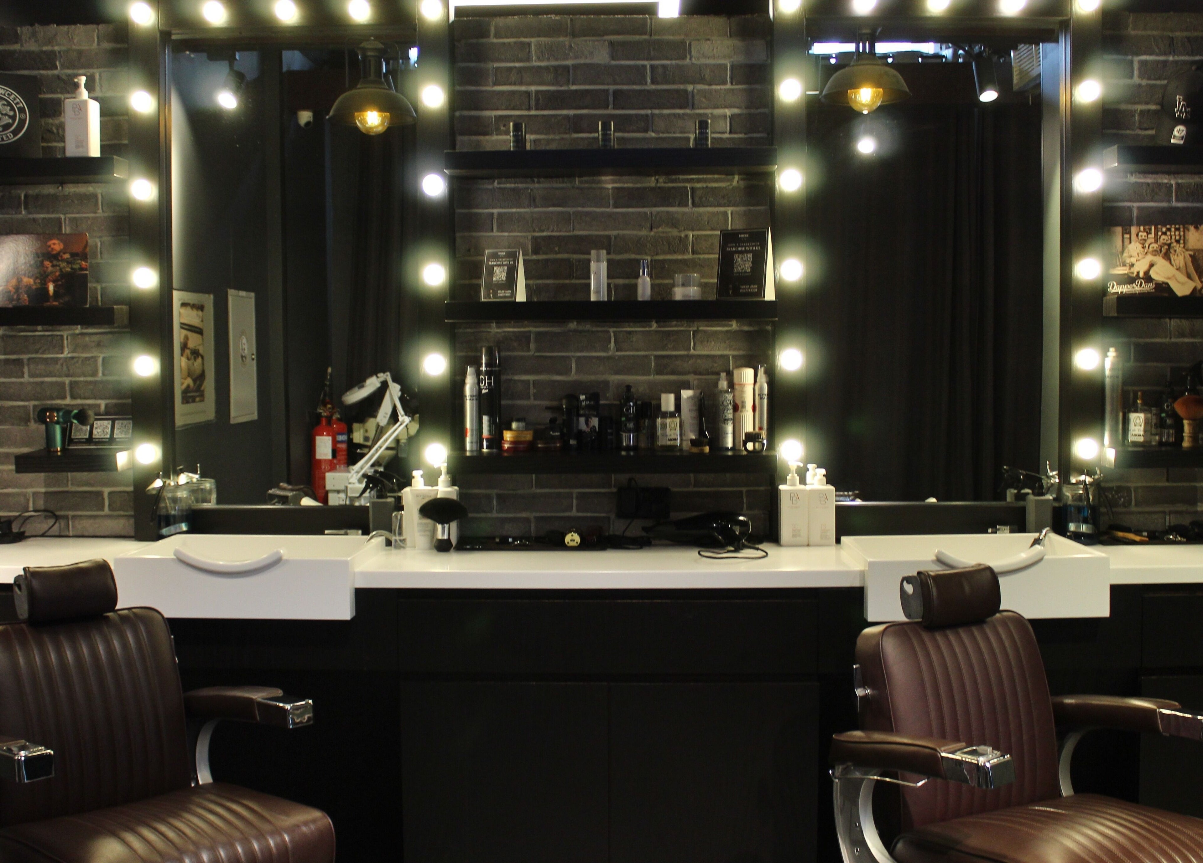 Modern grooming stations at Musk Barbershop JVC, Dubai, Dubai, AE, featuring sleek chairs and illuminated mirrors.