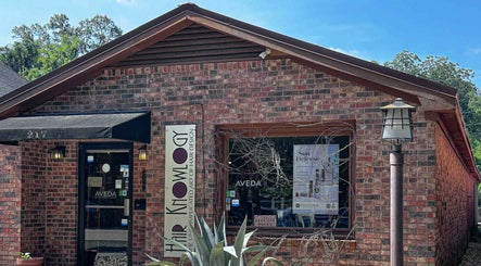 Entrance of Hair Knowlogy & Earthmuffin Spa in Aiken, South Carolina, US with brick exterior and signage.