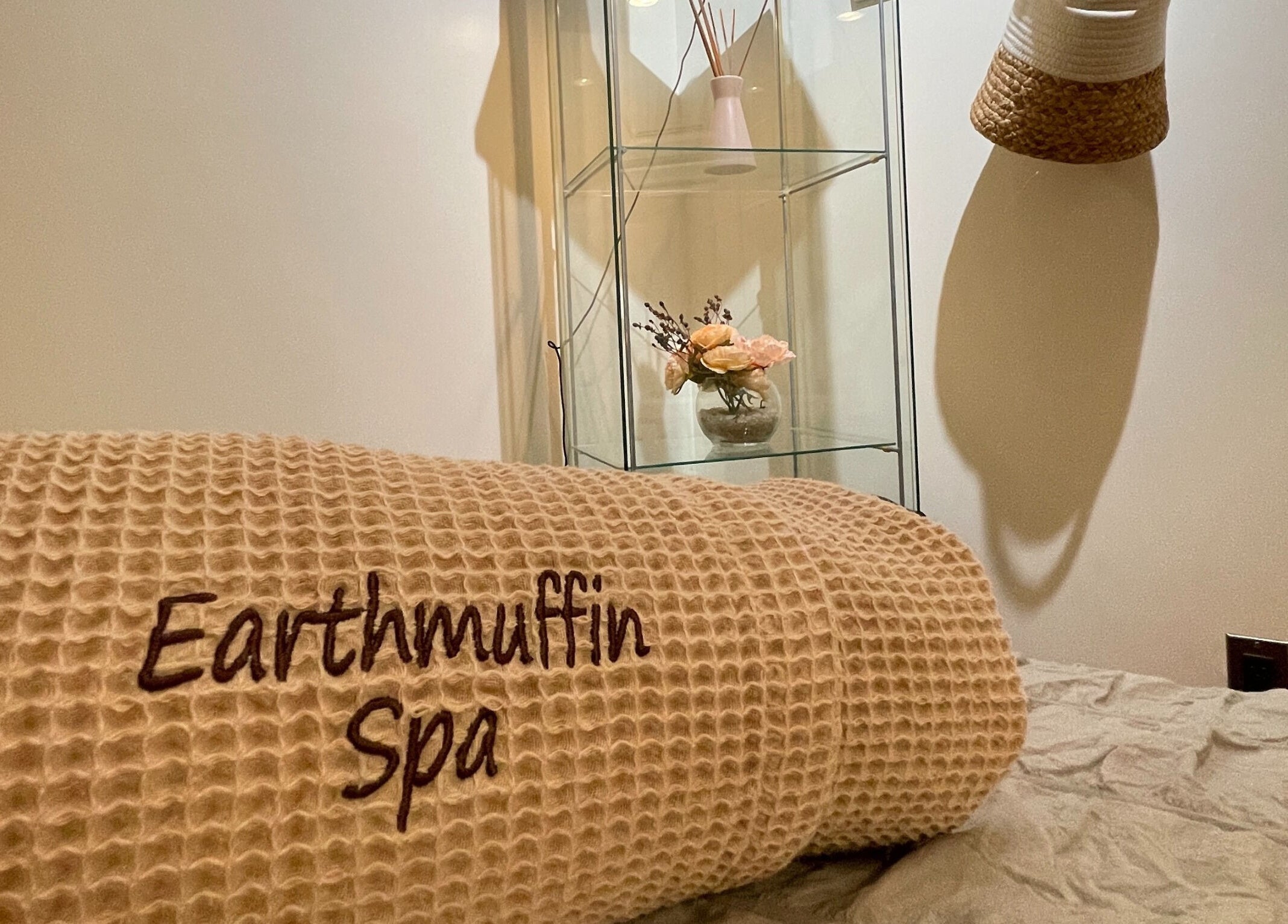 Relaxing treatment room at Earthmuffin Spa, Aiken, South Carolina, US, showcasing a cozy blanket and floral decor.