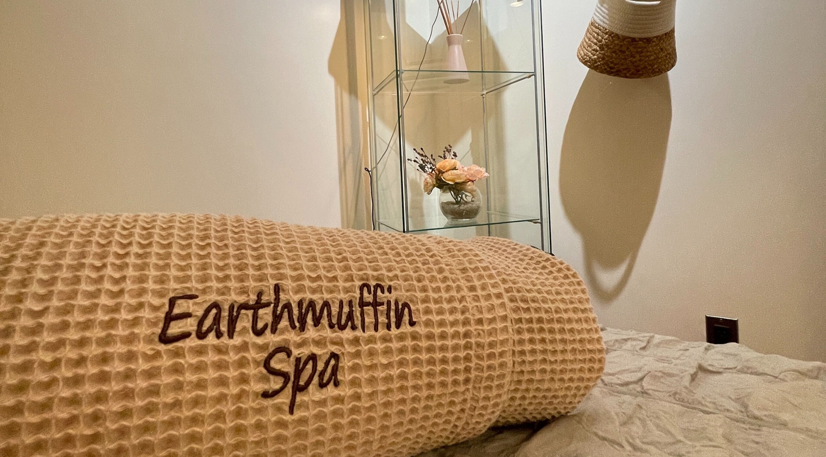 Relaxing treatment room at Earthmuffin Spa, Aiken, South Carolina, US, showcasing a cozy blanket and floral decor.
