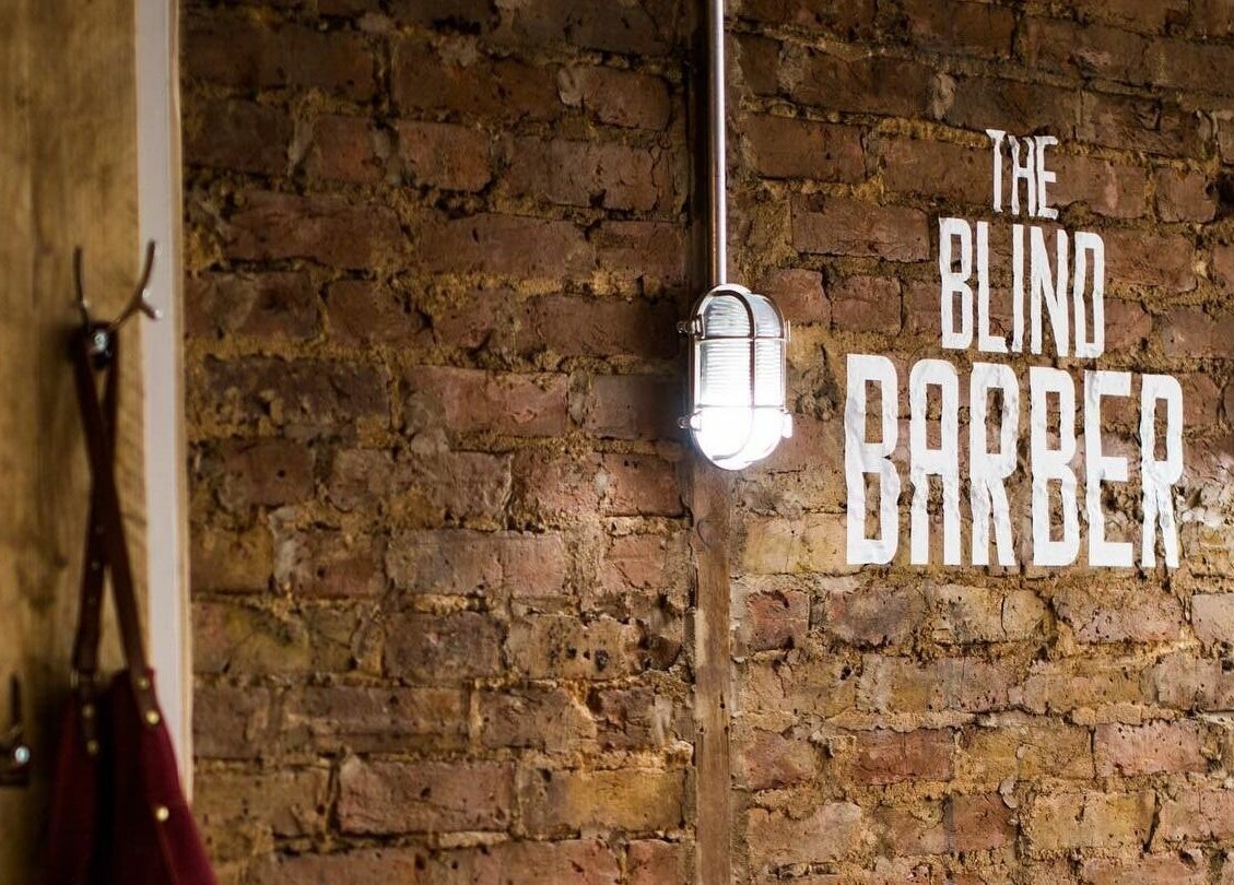 Exposed brick wall with The Blind Barber Leigh-On-Sea logo in Southend-on-Sea, England, GB.