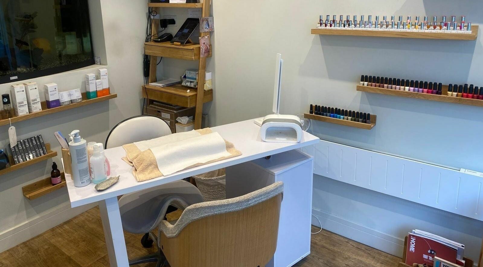 Nail salon interior at Seabrease, Sidmouth, England, GB featuring manicure essentials and vibrant polish display.