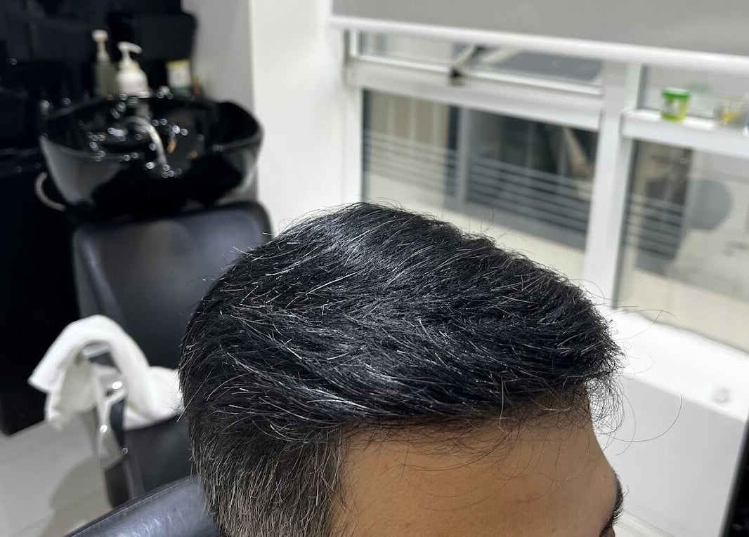 Modern salon interior at New Images, Dubai, 127825, AE, showcasing a stylish haircut on a client.