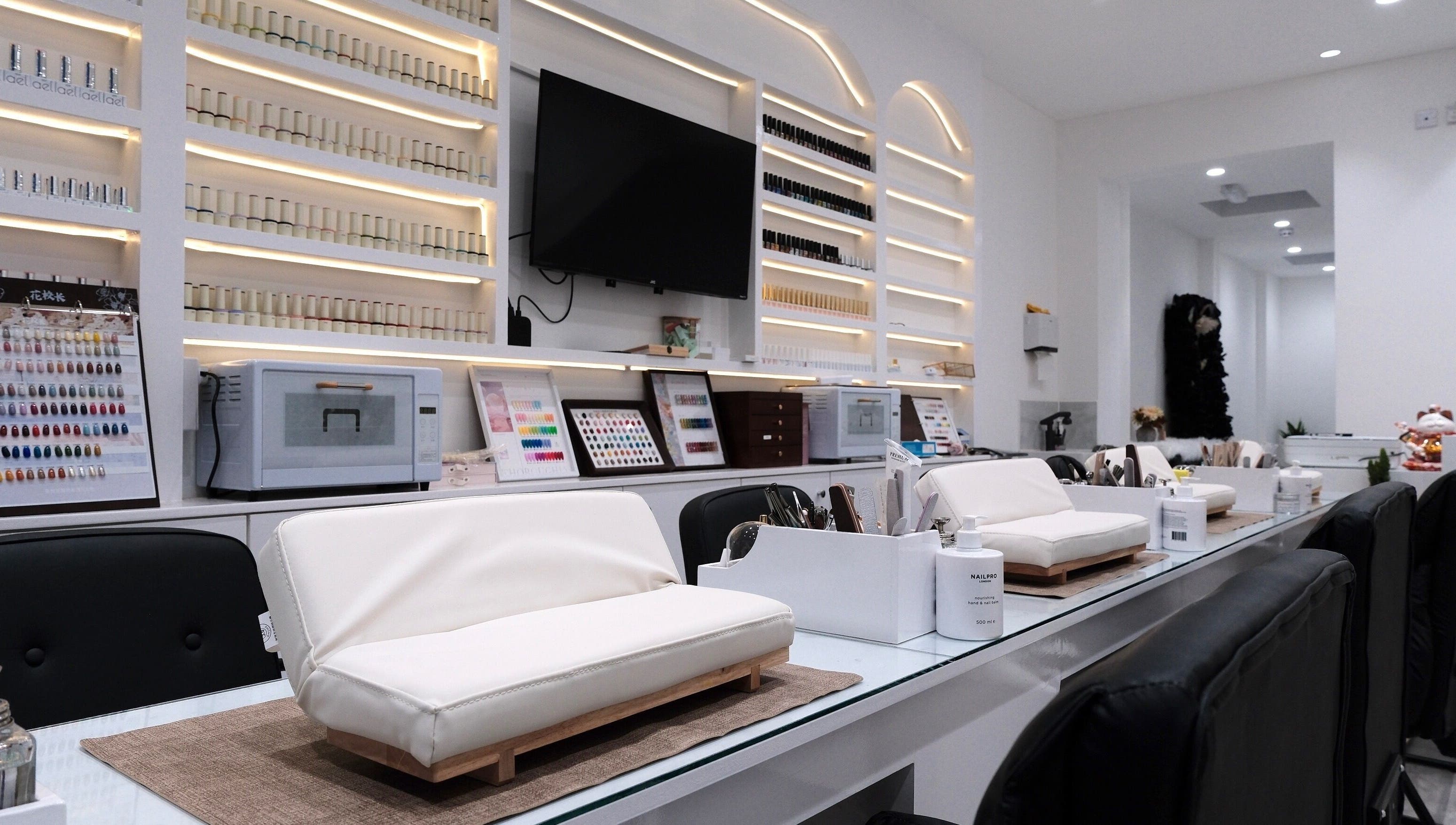 Elegant interior of Abby Nails Leyton in London, England, GB featuring nail stations and polish display.