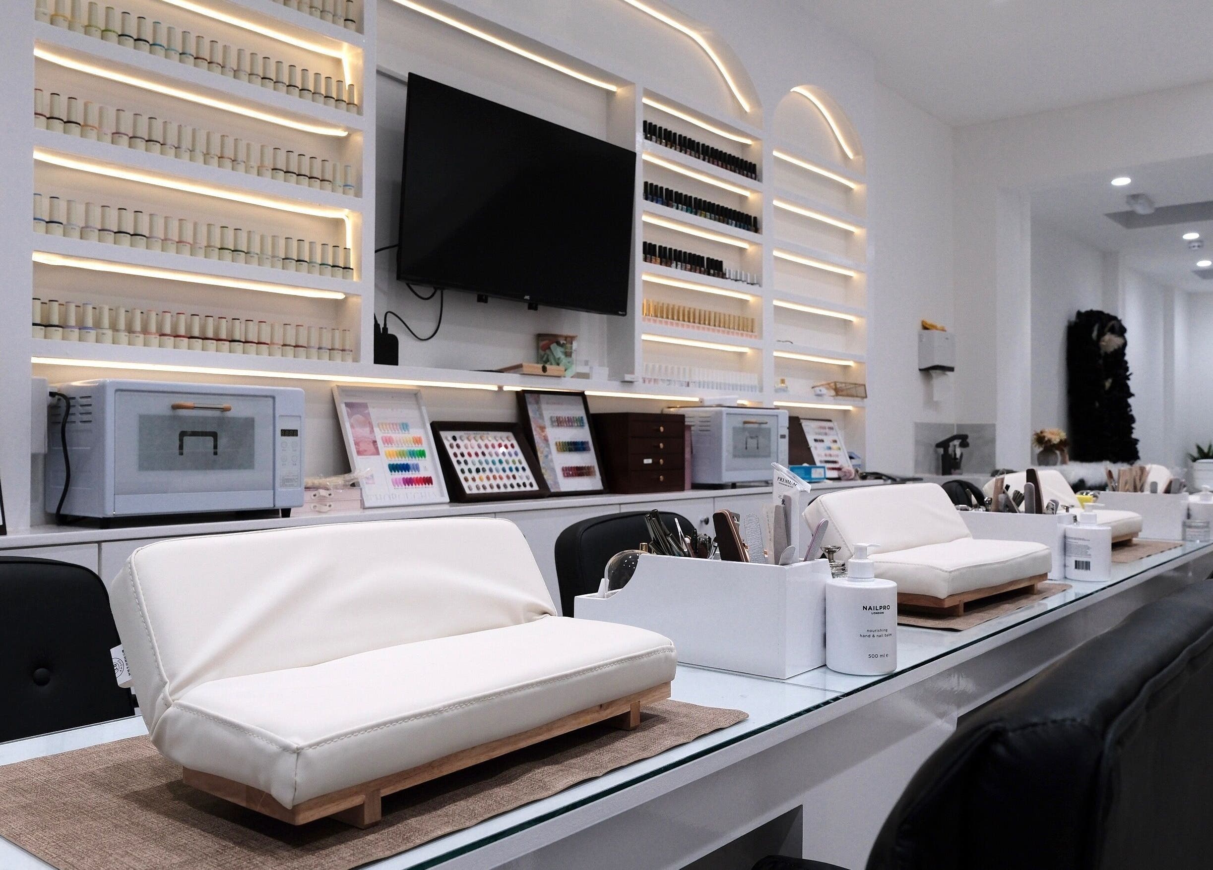Elegant interior of Abby Nails Leyton in London, England, GB featuring nail stations and polish display.