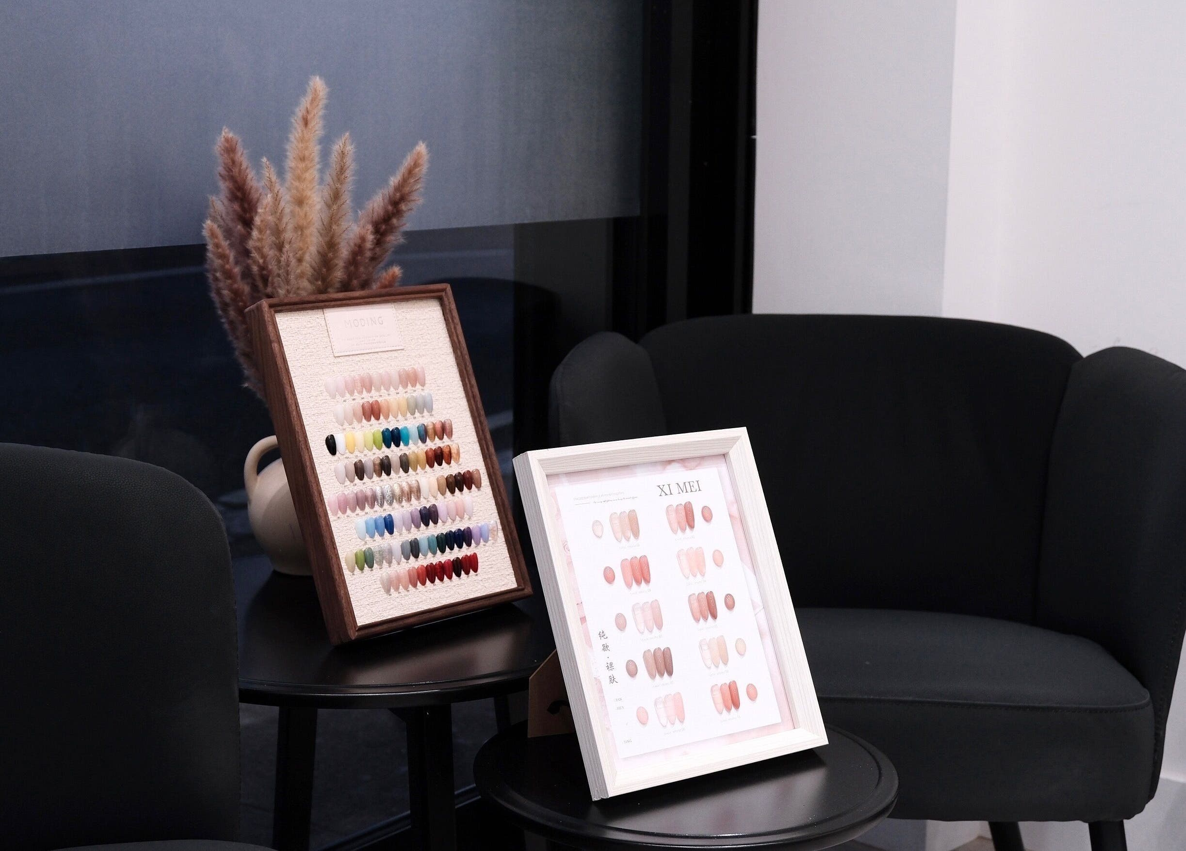 Nail color displays on tables at Abby Nails Leyton in London, England, GB, showcasing diverse nail art options.