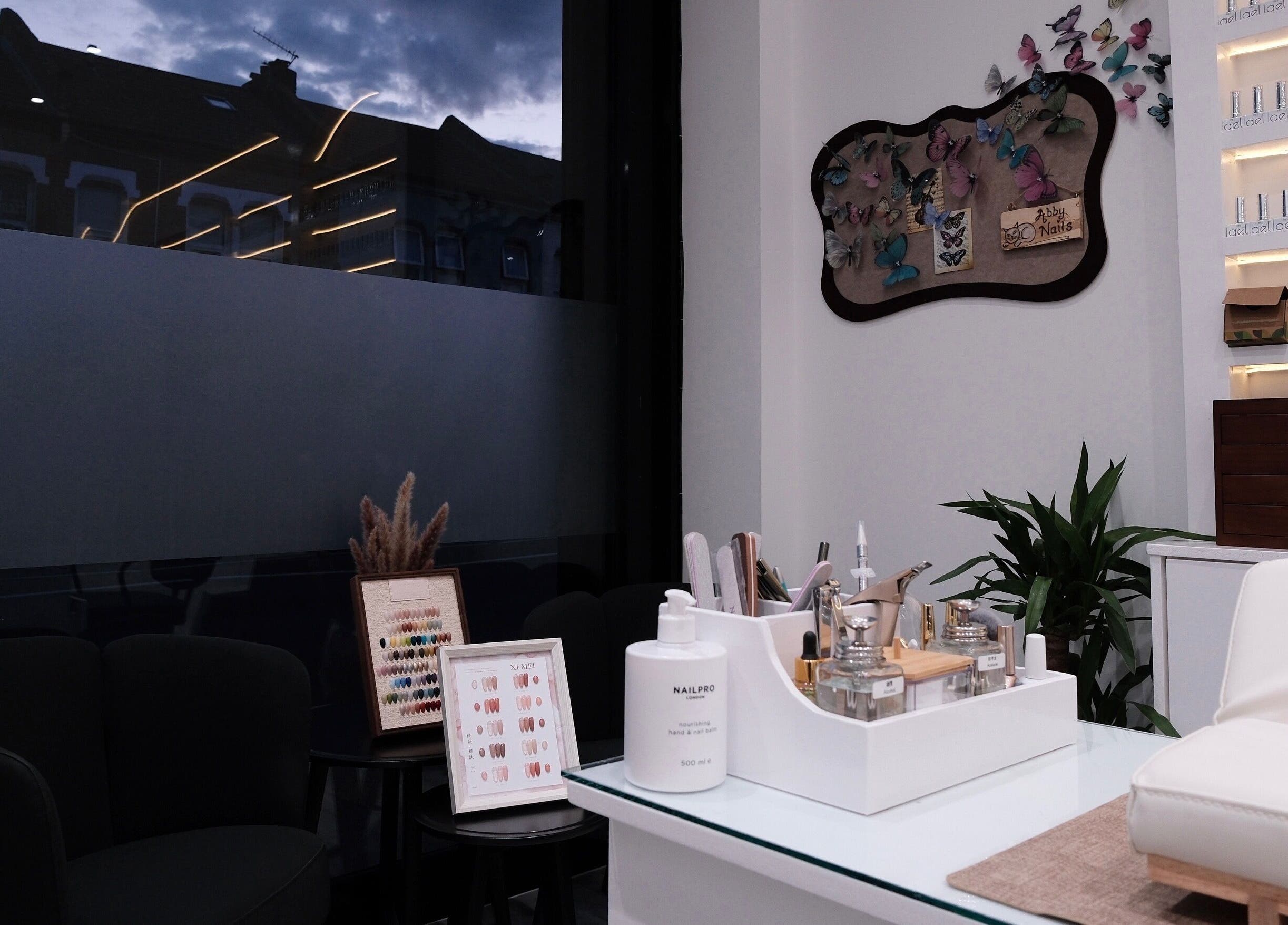 Elegant interior of Abby Nails Leyton, London, England, GB showcasing a manicure station and product display.